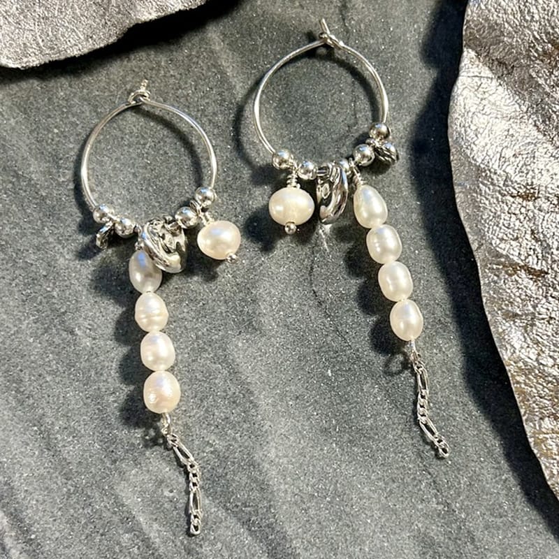 Her er et par smukke, håndlavede creoler i sølv med hvide ferskvandsperler