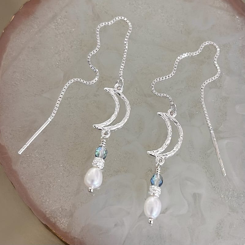 Lange ørekæder i sølv med måner er en god investering, hvis du skal pifte dit hverdagslook op på en billig og let måde